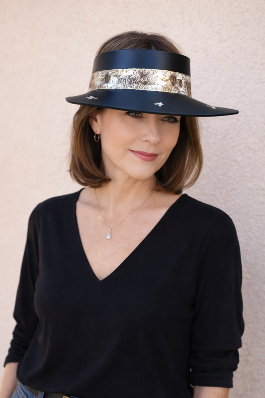 Woman wearing a black visor with sequin band against a beige background