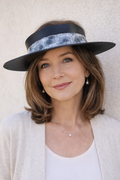 Woman wearing a wide-brimmed hat against a light background
