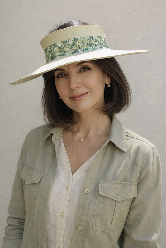 Woman wearing a wide-brimmed hat with floral band against a plain background