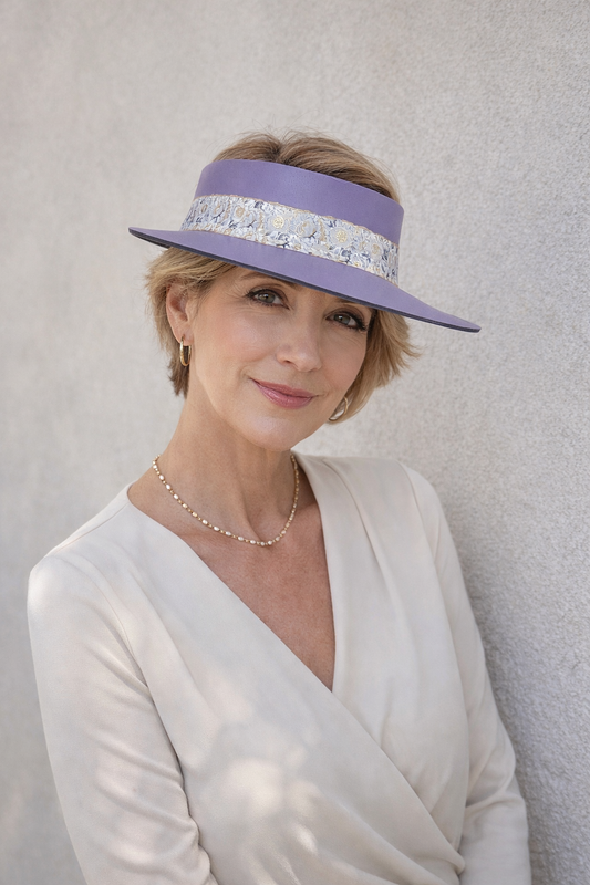 Woman wearing a light purple hat with a decorative band against a plain background