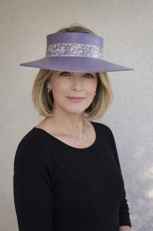 Woman wearing a purple hat with decorative band against a neutral background