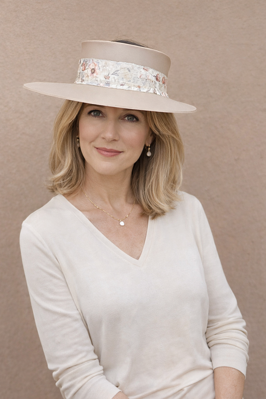 Woman wearing a wide-brimmed hat with floral band against a beige background