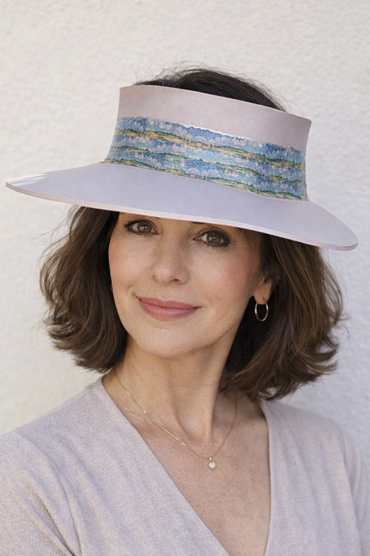 Woman wearing a wide-brimmed hat with decorative band against a white background