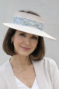 Woman wearing a white visor with a patterned band against a gray background