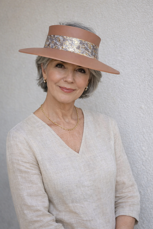 Woman wearing a wide-brimmed hat with a decorative band against a plain background