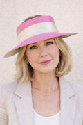 Woman wearing a pink and white visor against a light background