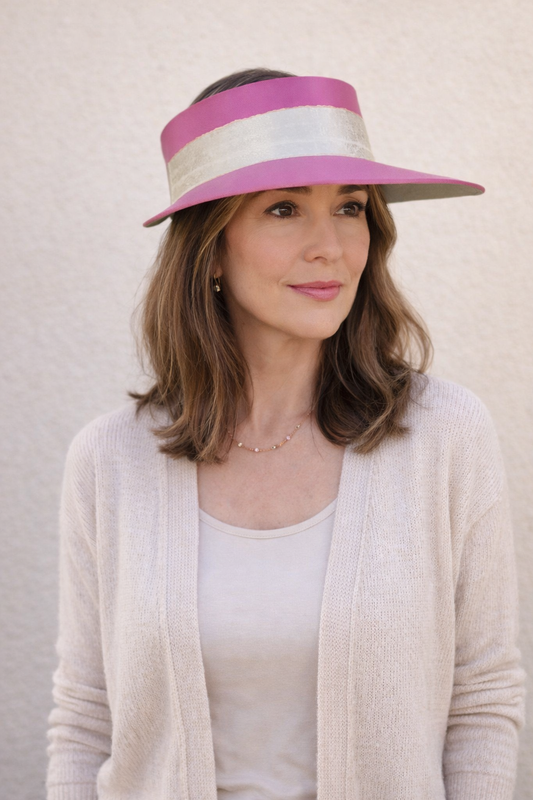 Woman wearing a pink and white visor against a plain background