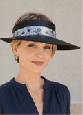 Woman wearing a black visor with a patterned band against a neutral background