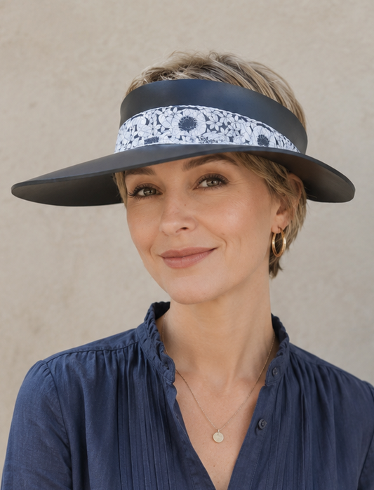 Woman wearing a navy blue visor and button-up shirt against a beige background