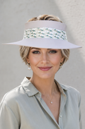 Woman wearing a white visor with decorative band against a plain background