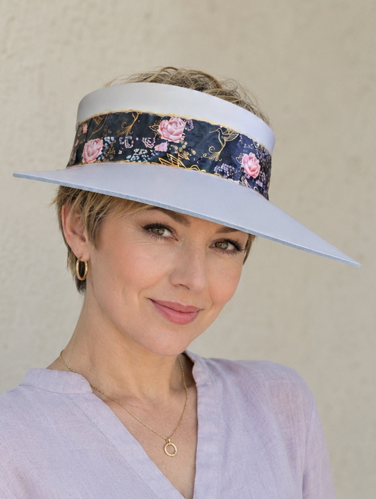 Woman wearing a light purple visor with floral design against a plain background