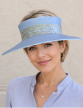 Woman wearing a light blue visor and matching shirt against a beige background