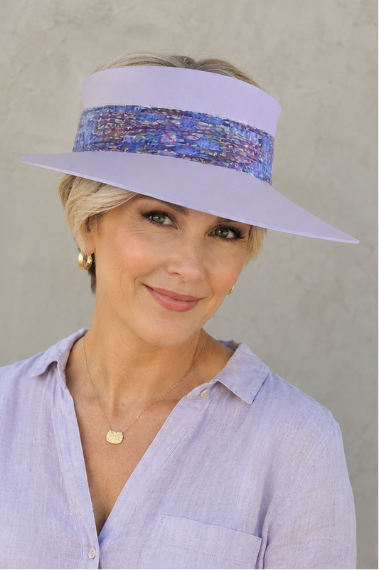 Woman wearing a light purple visor hat with a patterned band against a plain background