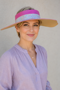 Woman wearing a colorful visor against a plain background