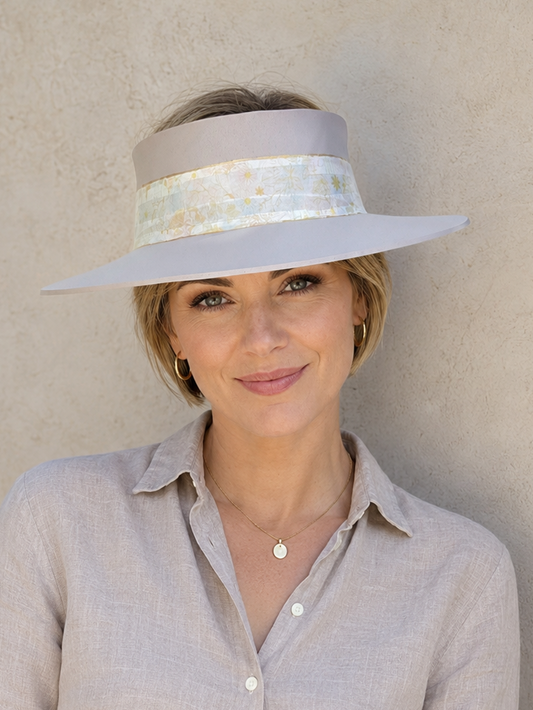 Woman wearing a light gray hat against a plain background