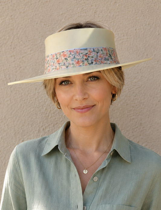 Woman wearing a light green visor and shirt against a beige wall