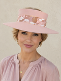 Woman wearing a pink visor and matching blouse against a plain background