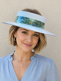 Woman wearing a light blue visor and blouse against a beige background