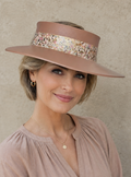 Woman wearing a wide-brimmed hat with decorative band against a neutral background