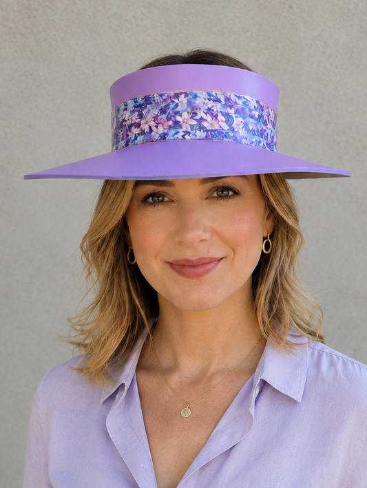 Woman wearing a purple visor and matching shirt against a gray background