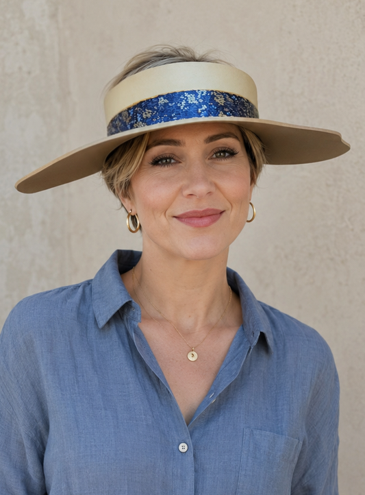 Woman wearing a wide-brimmed hat with a blue band against a neutral background