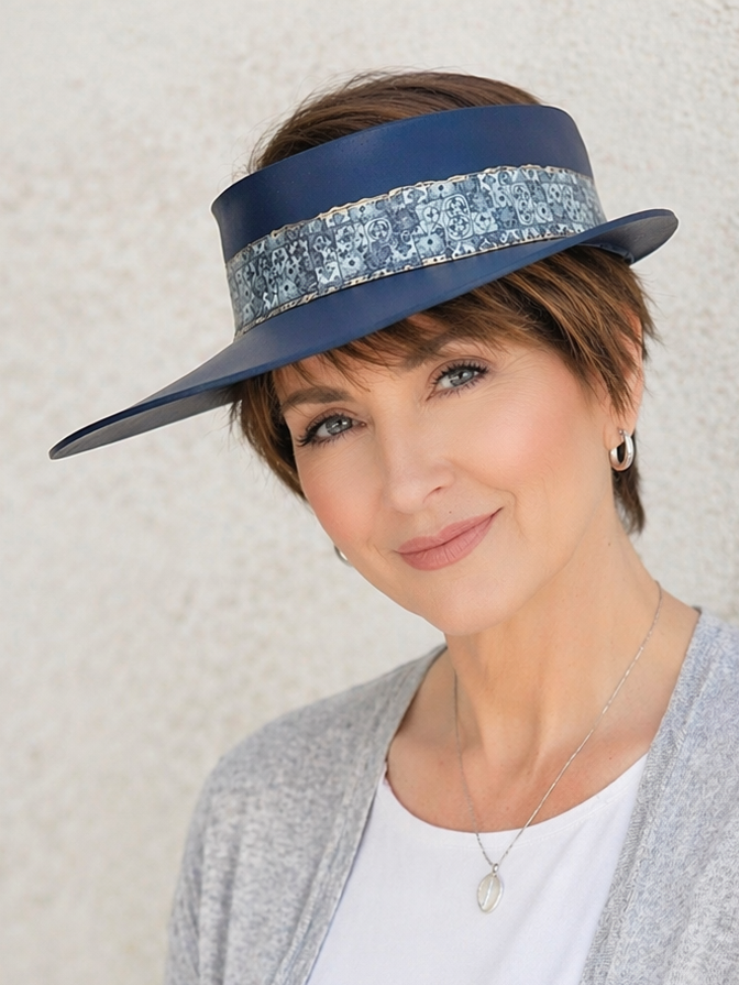 Woman wearing a blue visor with a patterned band against a neutral background