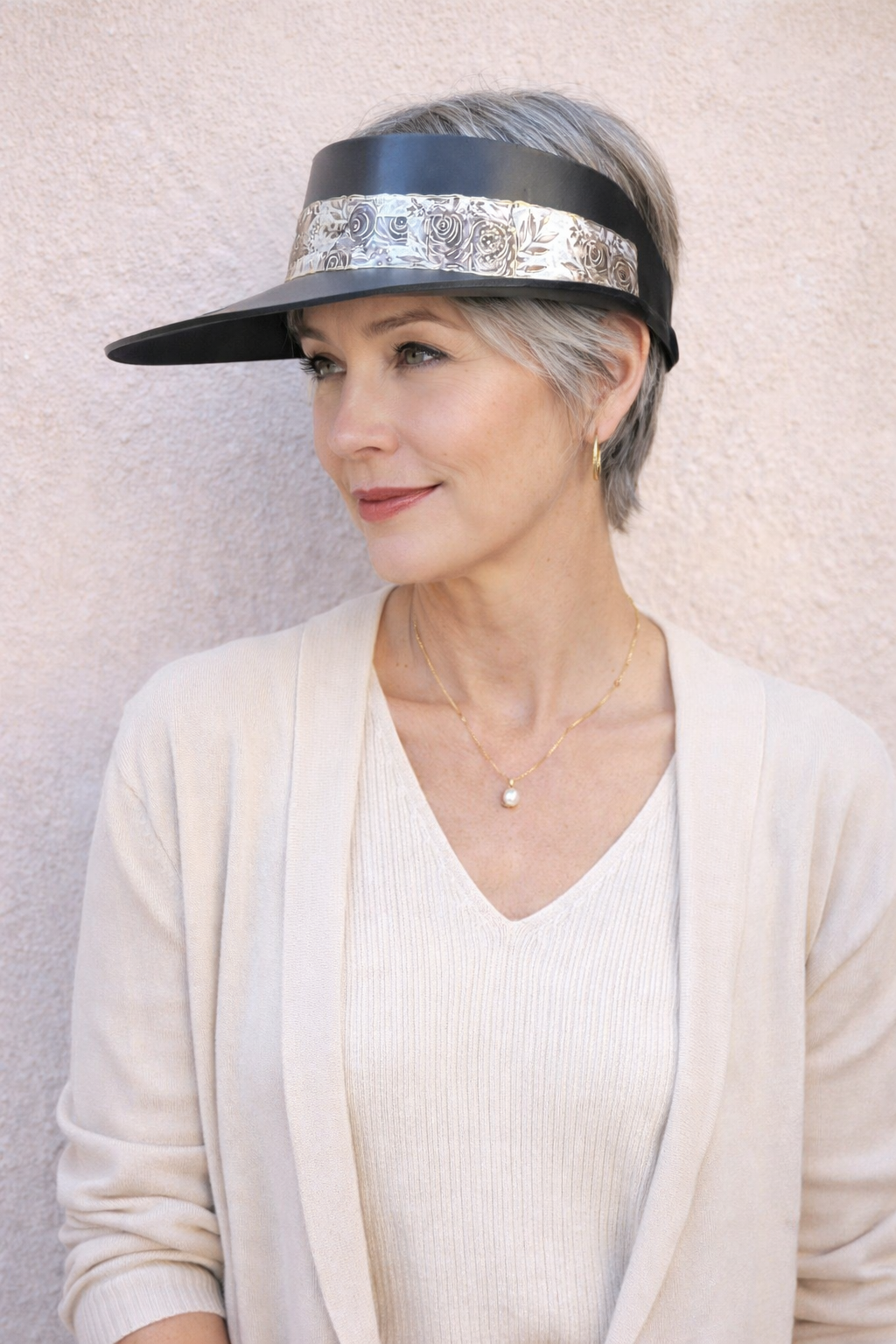 Woman wearing a visor with a floral pattern against a plain background