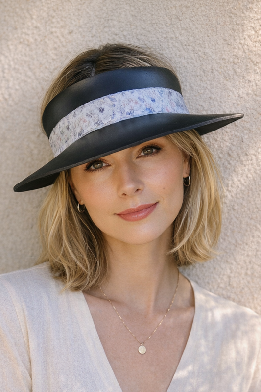 Woman wearing a black and white visor hat against a neutral background