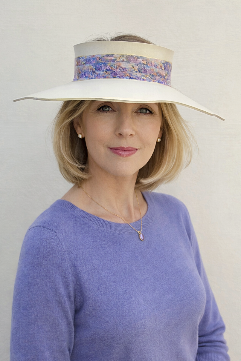 Woman wearing a wide-brimmed hat with floral band against a plain background