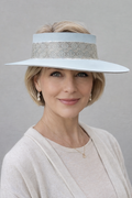 Woman wearing a white hat with a gray band against a gray background