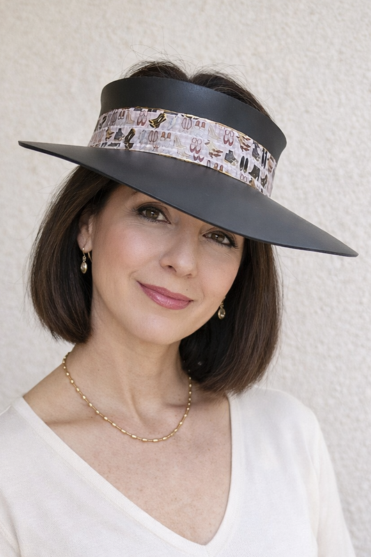 Woman wearing a wide-brimmed hat with decorative band against a plain background