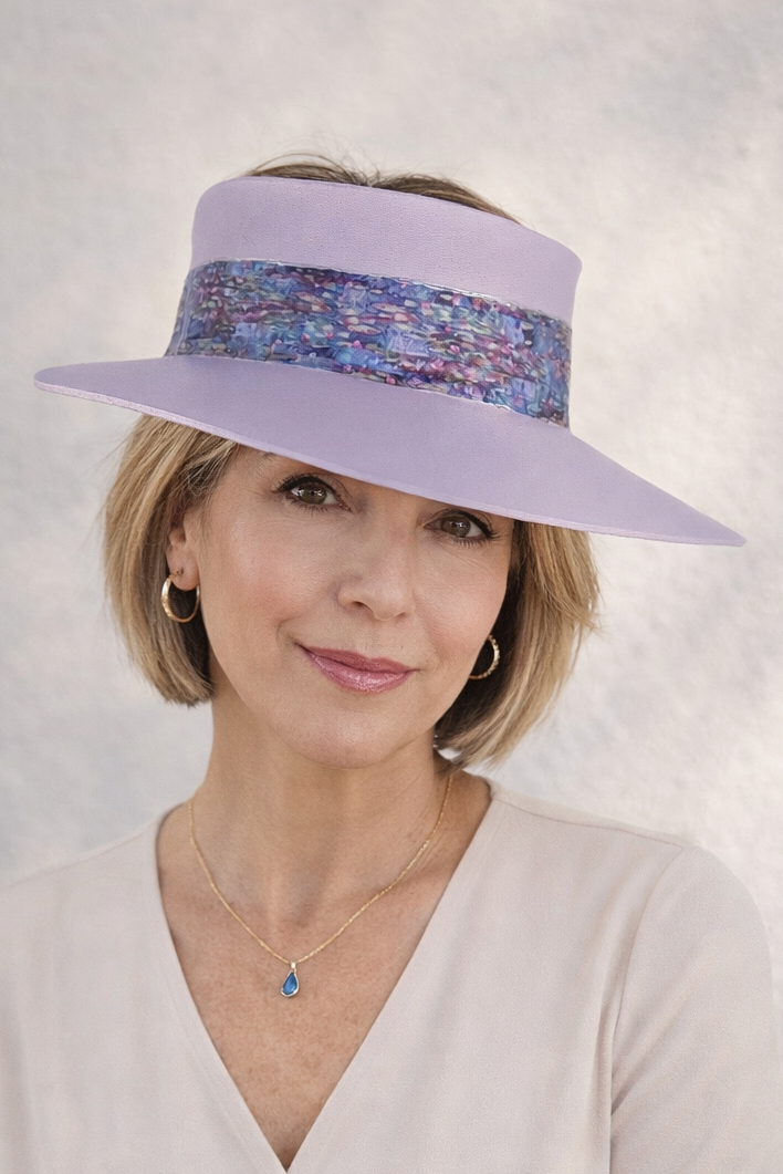 Woman wearing a light purple visor with a patterned band against a gray background