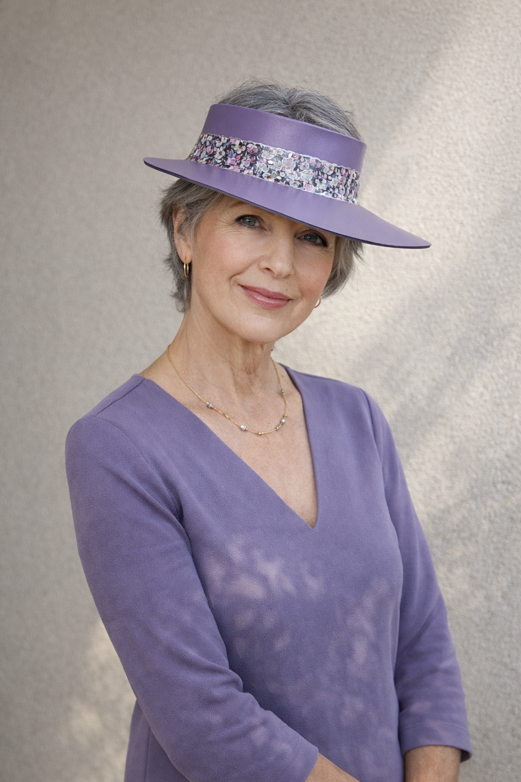 Woman wearing a purple visor and matching outfit against a neutral background