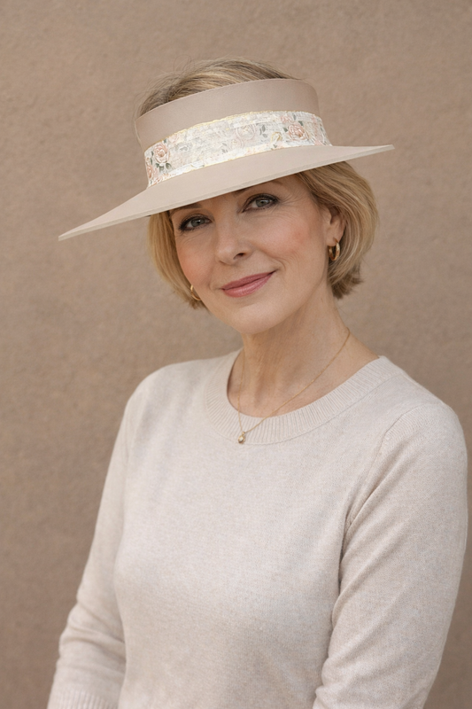 Woman wearing a beige hat with a decorative band against a beige background