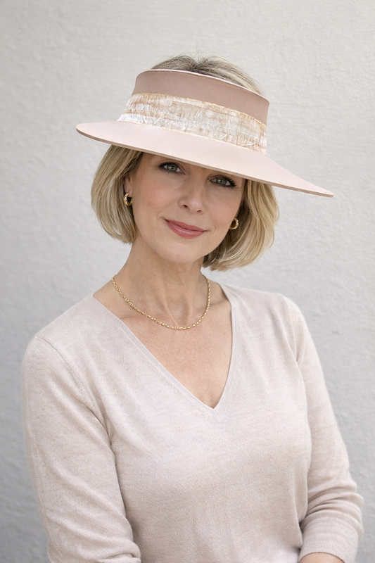 Woman wearing a wide-brimmed hat with decorative band against a plain background