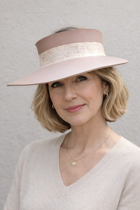 Woman wearing a beige hat with a wide brim against a plain background