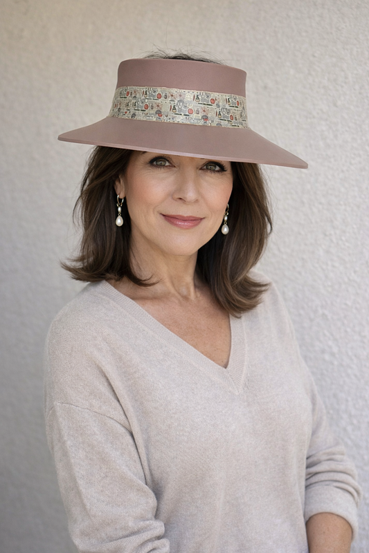 Woman wearing a wide-brimmed hat with a floral band against a neutral background