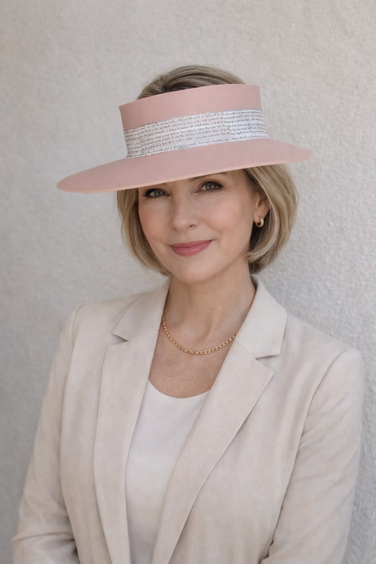 Woman wearing a pink hat with a textured band against a light background