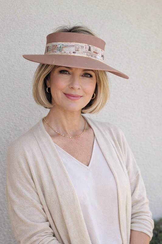 Woman wearing a wide-brimmed hat with a decorative band against a plain background