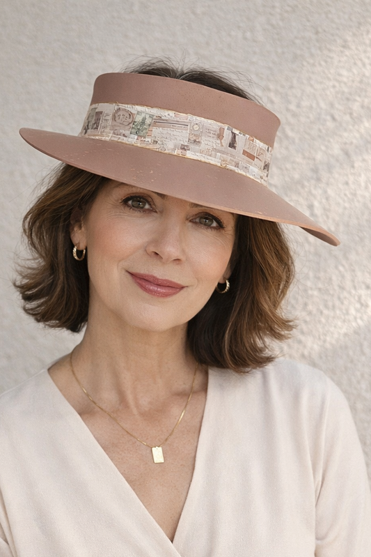 Woman wearing a beige visor hat and white top against a light background