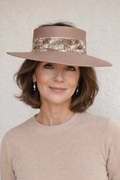 Woman wearing a beige hat and sweater against a plain background