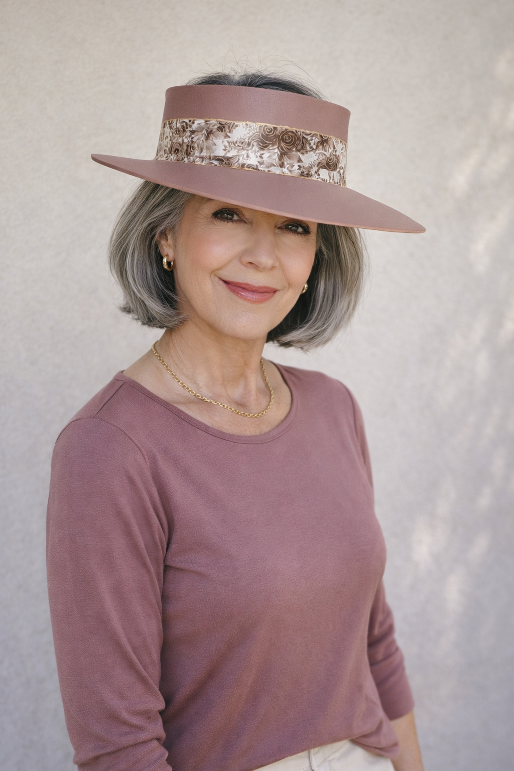 Woman wearing a wide-brimmed hat with sequin trim against a plain background