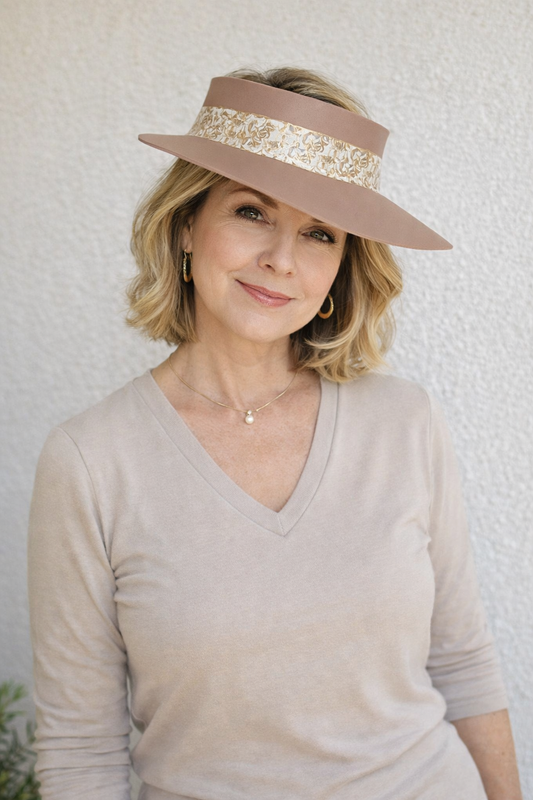 Woman wearing a beige visor with a decorative band against a white background