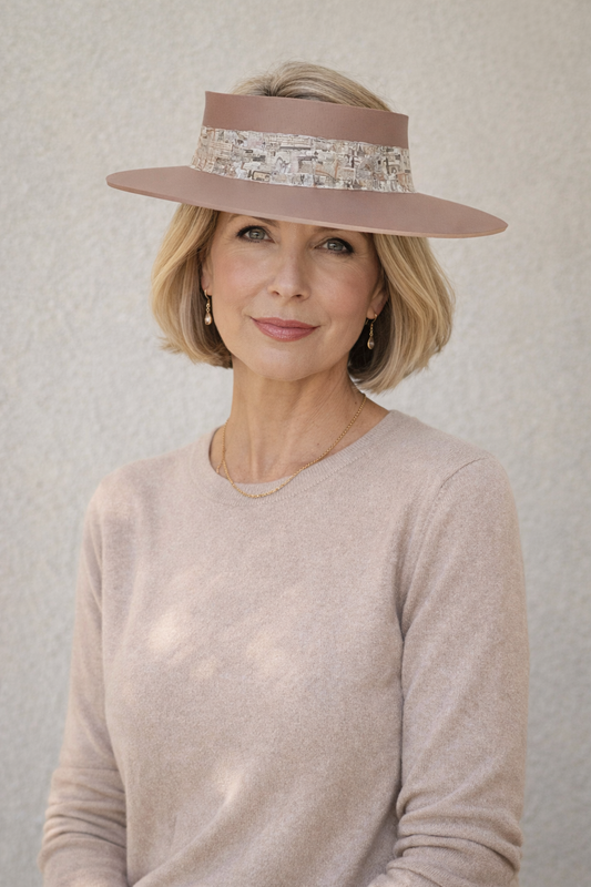 Woman wearing a wide-brimmed hat with decorative band against a neutral background