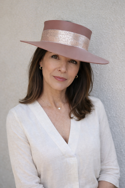 Woman wearing a wide-brimmed hat against a plain background