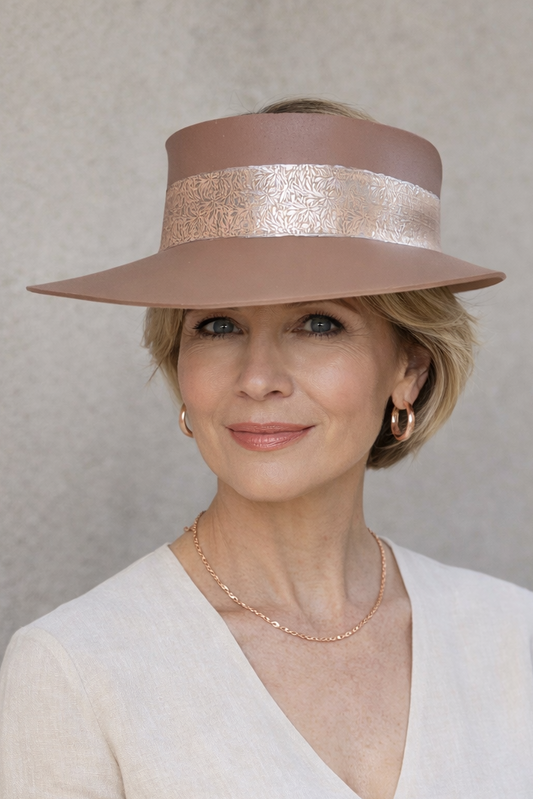 Woman wearing a beige hat and white sweater against a plain background