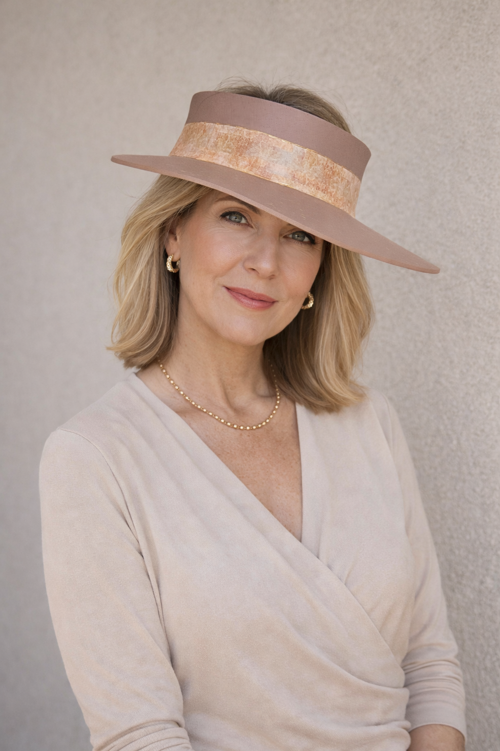 Woman wearing a wide-brimmed hat with a neutral background