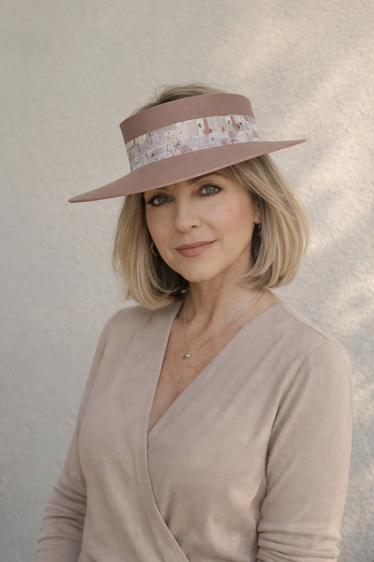 Woman wearing a wide-brimmed hat with a patterned band against a neutral background
