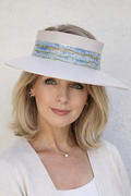 Woman wearing a white sun hat with a colorful band against a plain background