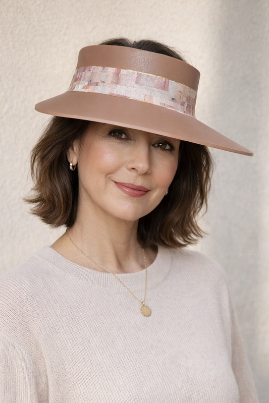 Woman wearing a wide-brimmed hat against a neutral background